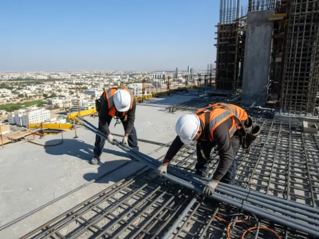 Workers installing rooftop conduits